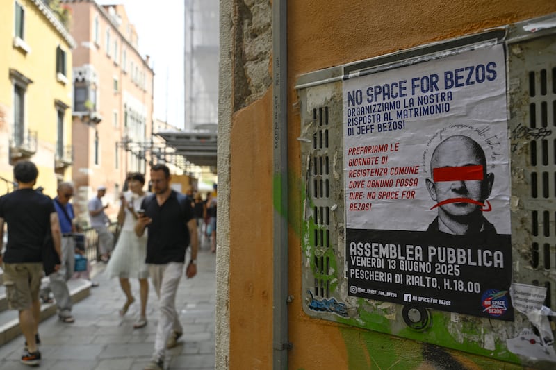 TOPSHOT - A poster reading "No Space for Bezos" and calling for protest, is pasted on a wall in Venice where the billionaire Jeff Bezos will marry is fiancee, journalist Lauren Sanchez at the end of the month, on June 13, 2025. Poster campaigns and stickers have spread throughout the city, including one with images of Bezos reading "No space for Bezos" as some local residents protest claiming the city is transformed into a playground for billionaires. (Photo by ANDREA PATTARO / AFP) (Photo by ANDREA PATTARO/AFP via Getty Images)