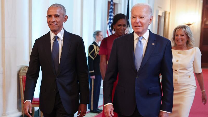 Barack Obama and Joe Biden walk down the hall in the White House in 2022.