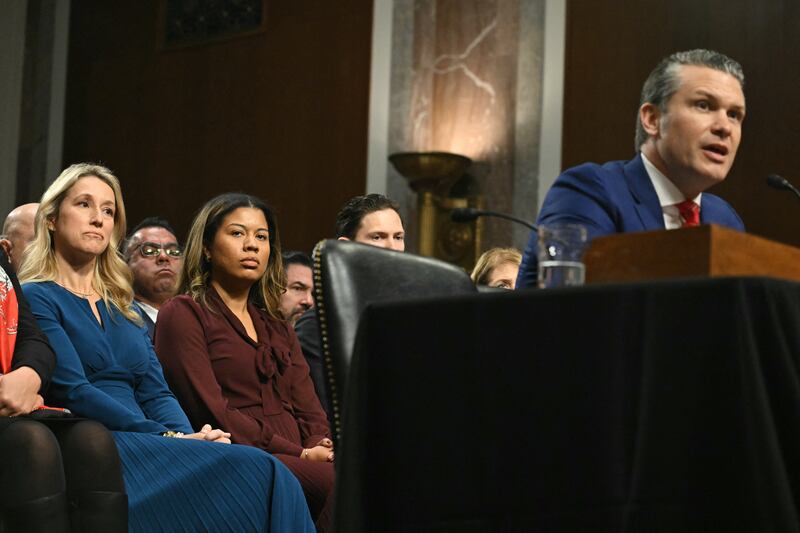 Jennifer Rauchet (L), wife of Pete Hegseth, looks on as he testifies during his confirmation hearing.