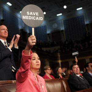Rep. Jill Tokuda (D-HI) holds a protest sign with fellow Democrats as U.S. President Donald Trump addresses a joint session of Congress at the U.S. Capitol on March 04, 2025 in Washington, DC.