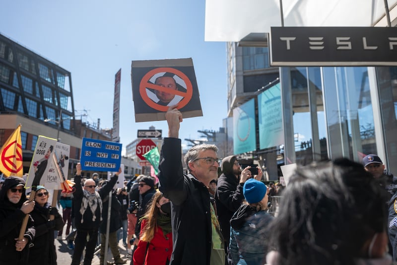 Protesters gather outside of a Manhattan Tesla dealership on Saturday.