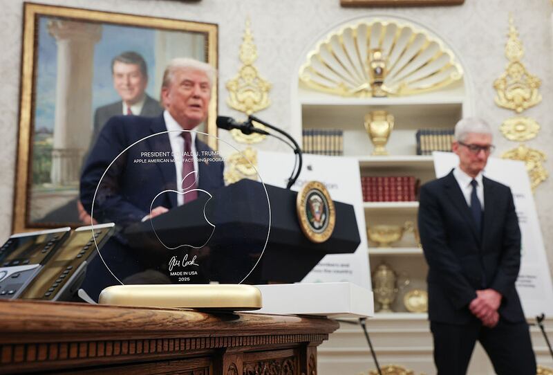 WASHINGTON, DC - AUGUST 06: U.S. President Donald Trump speaks behind an engraved glass disc presented to him by Apple CEO Tim Cook during an event in the Oval Office of the White House on August 6, 2025 in Washington, DC. Apple Inc. announced a $100 billion investment in manufacturing facilities in the U.S., on top of an announcement in February committing over the next four years to a $500 billion investment in the U.S. economy and the addition of 20,000 new jobs. (Photo by Win McNamee/Getty Images)