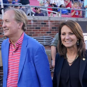 Texas Attorney General Ken Paxton, left, walks with his wife and Texas State Sen. Angela Paxton on the sideline before an NCAA college football game between Navy and SMU in Dallas, Friday, Oct. 14, 2022.