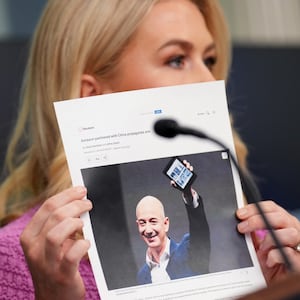 White House press secretary Karoline Leavitt holds a news article on Amazon CEO Jeff Bezos as she speaks during the daily press briefing in the Brady Press Briefing Room at the White House on April 29, 2025 in Washington, DC.