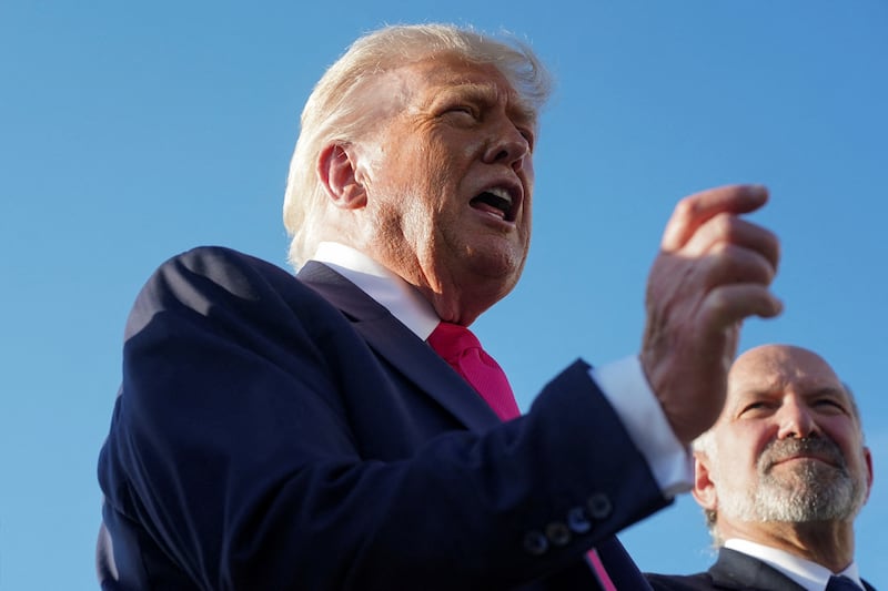 U.S. President Donald Trump speaks with the media upon his arrival from Pennsylvania, as U.S. Secretary of Commerce Howard Lutnick looks on, at Joint Base Andrews, Maryland, U.S., July 15, 2025. REUTERS/Nathan Howard