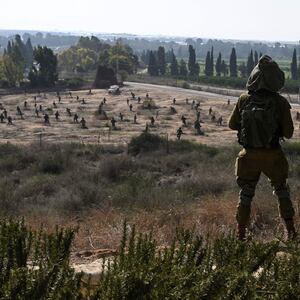 Two Israeli soldiers stand in Kibbutz Yad Mordechai, over looking a sculpture park in the grounds of the Yad Mordechai Museum, close to Israel's northern border with the Gaza Strip