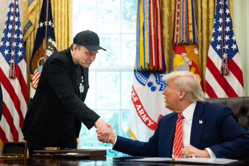 Elon Musk shakes the hand of President Trump
