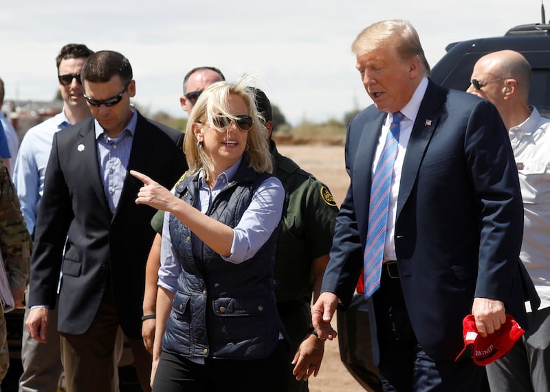 Kirstjen Nielsen talks with Donald Trump during a visit to the U.S. southern border in 2019.