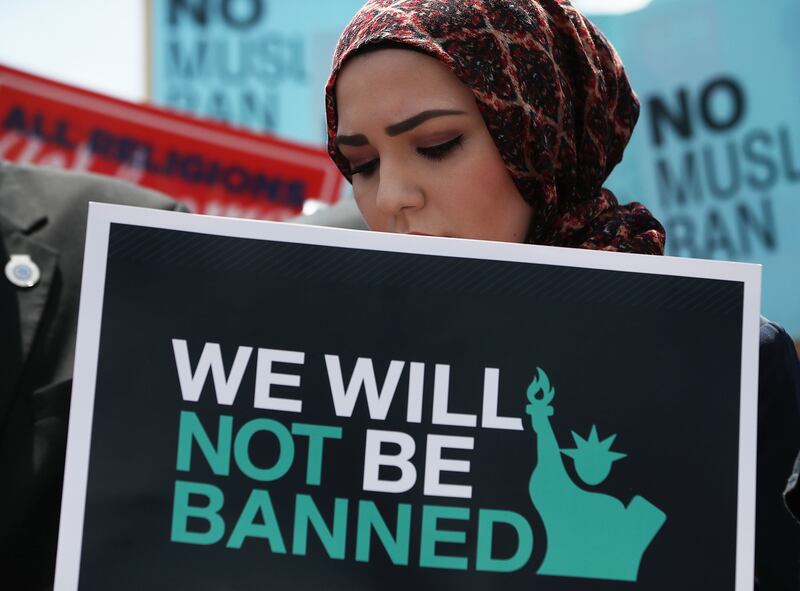 A women protests against U.S. President Trump's Muslim travel ban as protesters gather outside the U.S. Supreme Court in 2018.