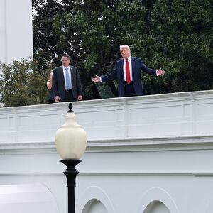 U.S. President Donald Trump gestures while answering questions from reporters as he tours the roof of the West Wing of the White House