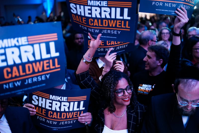 Supporters wave signs at the election night watch party for New Jersey Democratic gubernatorial candidate, Rep. Mikie Sherrill in East Brunswick, New Jersey while celebrating her victory.