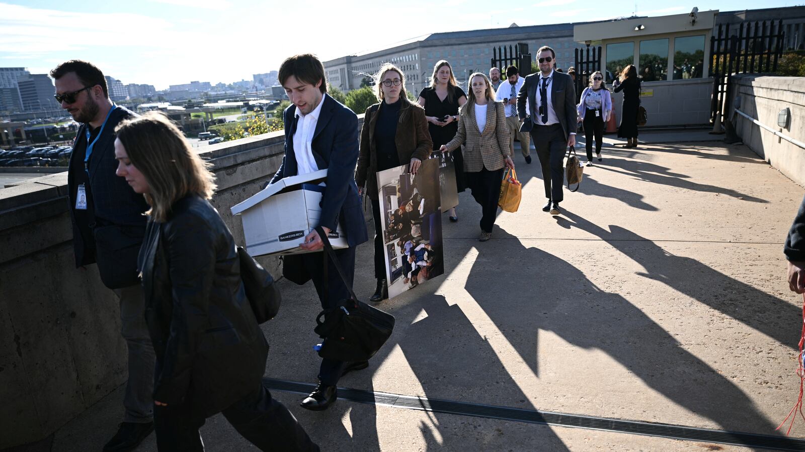 Reporters carry their belongings from the Pentagon in Washington, DC, on October 15, 2025 after US and international news outlets including The New York Times, AP, AFP and Fox News declined to sign new restrictive Pentagon media rules, and were stripped of their press access credentials. The new rules come after the Defense Department restricted media access inside the Pentagon, forced some outlets to vacate offices in the building and drastically reduced the number of briefings for journalists. (Photo by Brendan SMIALOWSKI / AFP) (Photo by BRENDAN SMIALOWSKI/AFP via Getty Images)