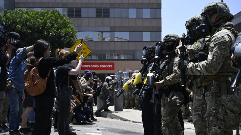 ICE officers and national guards face off with protesters outside of the Metropolitan Detention Center in Los Angeles on Sunday.