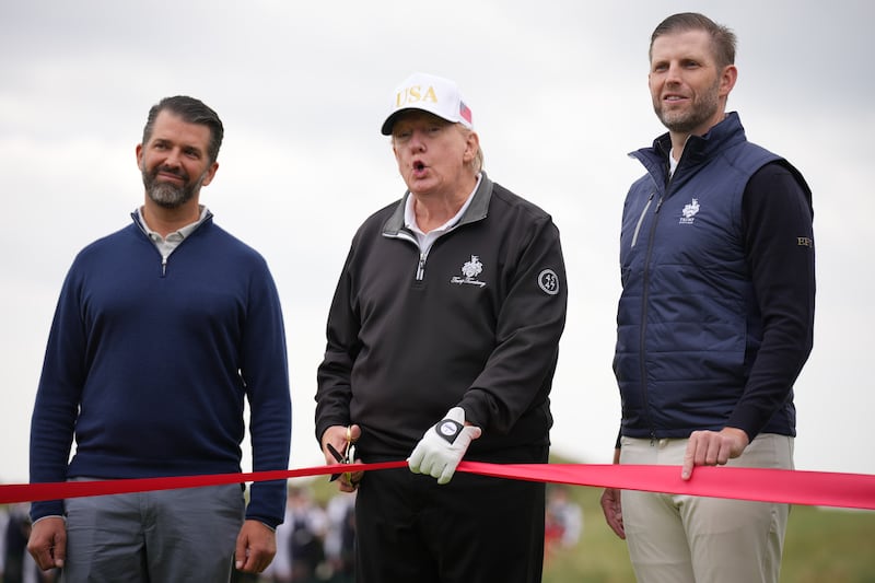 BALMEDIE, SCOTLAND - JULY 29: U.S. President Donald Trump speaks next to Donald Trump Jr. (L) and Eric Trump as they attend the ribbon-cutting ceremony at a new 18-hole course at Trump International Golf Links on July 29, 2025 in Balmedie, near Aberdeen, Scotland. President Trump is visiting Scotland in a trip that’s part-vacation, part-work, as he stayed at his Trump Turnberry golf course, followed by Trump International Golf Links in Aberdeenshire, between July 25 to 29. (Photo by Andrew Harnik/Getty Images)