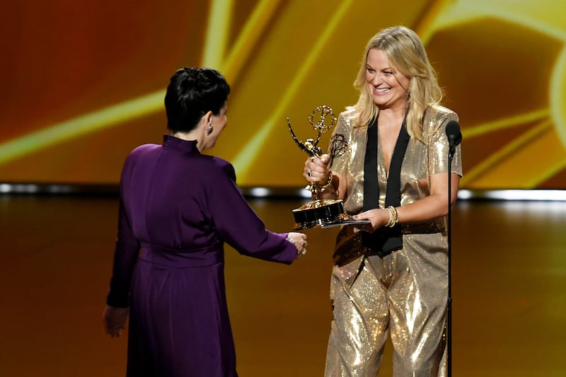LOS ANGELES, CALIFORNIA - SEPTEMBER 22: Alex Borstein accepts the Outstanding Supporting Actress in a Comedy Series award for 'The Marvelous Mrs. Maisel' from Amy Poehler onstage during the 71st Emmy Awards at Microsoft Theater on September 22, 2019 in Los Angeles, California. (Photo by Kevin Winter/Getty Images)