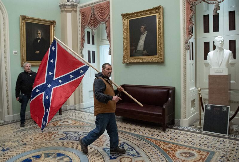 A man carrying a Confederate flag in the US Capitol Building during the January 6, 2021 Insurrection.