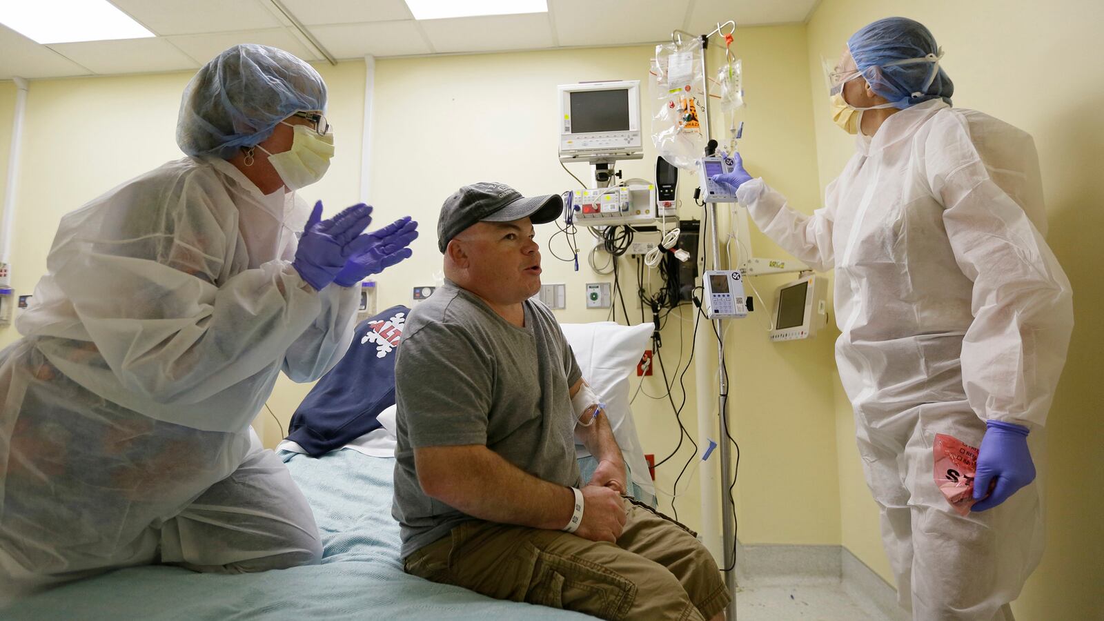 In this photo taken Monday, Nov. 13, 2017, Brian Madeux, 44, starts to receive the first human gene editing therapy for Hunter syndrome, as his girlfriend Marcie Humphrey, left, applauds at the UCSF Benioff Children's Hospital in Oakland, Cal.