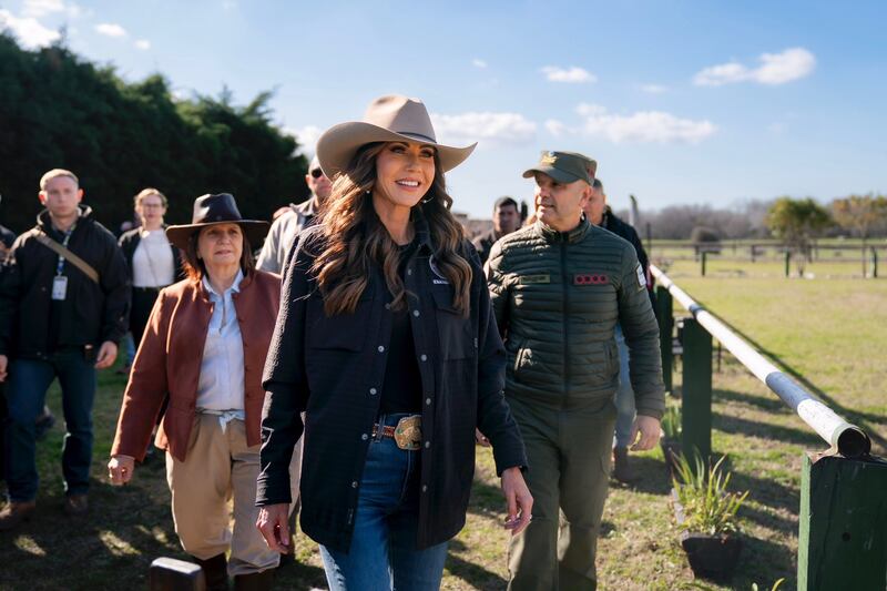 Kristi Noem wears a cowboy hat and walks a few steps ahead of Argentina's Security Minister Patricia Bullrich at the country's Campo de Mayo army base.