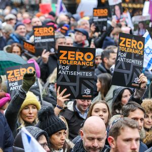 Protesters with placards and flags march on the street during the demonstration.