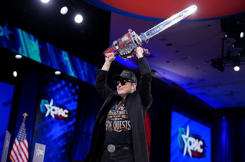 Elon Musk wields a chainsaw that he was gifted by Argentinian President Javier Milei, meant to symbolize his metaphorical slashing of the American federal government.