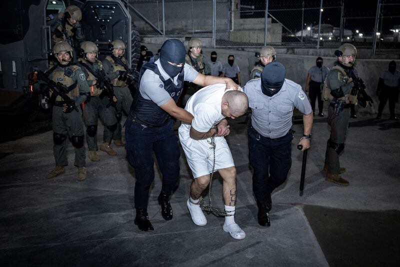 Police officers escort an alleged member of the Venezuelan gang Tren de Aragua, recently deported by the U.S. government, to be imprisoned in the Terrorism Confinement Center prison in Tecoluca, El Salvador, in this handout image obtained March 16, 2025.