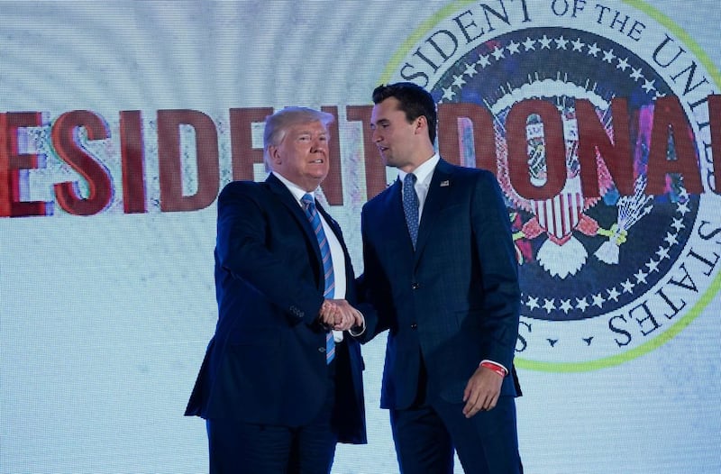 US President Donald Trump shakes hands with Charlie Kirk, head of Turning Point USA, before addressing the Turning Point USAs Teen Student Action Summit in Washington, DC, on July 23, 2019. (Photo by NICHOLAS KAMM / AFP)        (Photo credit should read NICHOLAS KAMM/AFP via Getty Images)