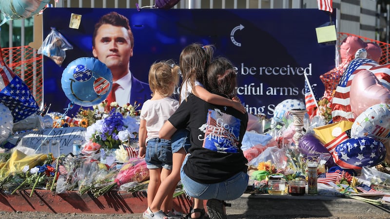 PHOENIX, ARIZONA - SEPTEMBER 16: (L-R)  Braxley Lambertson, Huxley Lambertson, and their mother, Keslyn Lambertson, visit a makeshift memorial for Charlie Kirk outside of the headquarters of Turning Point USA on September 16, 2025, in Phoenix, Arizona. Kirk, the CEO and co-founder of Turning Point USA, was shot and killed on September 10th while speaking at an event for his "American Comeback Tour" at Utah Valley University. (Photo by Joe Raedle/Getty Images)