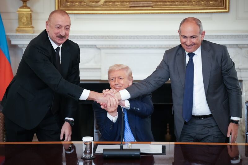 WASHINGTON, DC - AUGUST 08: U.S. President Donald Trump (C) joins hands with Azerbaijani President Ilham Aliyev (L), and Armenian Prime Minister Nikol Pashinyan (R) during a signing ceremony in the State Dining Room of the White House on August 8, 2025 in Washington, DC. The signed agreement is intended to bring an end to the conflict between Armenia and Azerbaijani that has lasted for decades.  (Photo by Andrew Harnik/Getty Images)