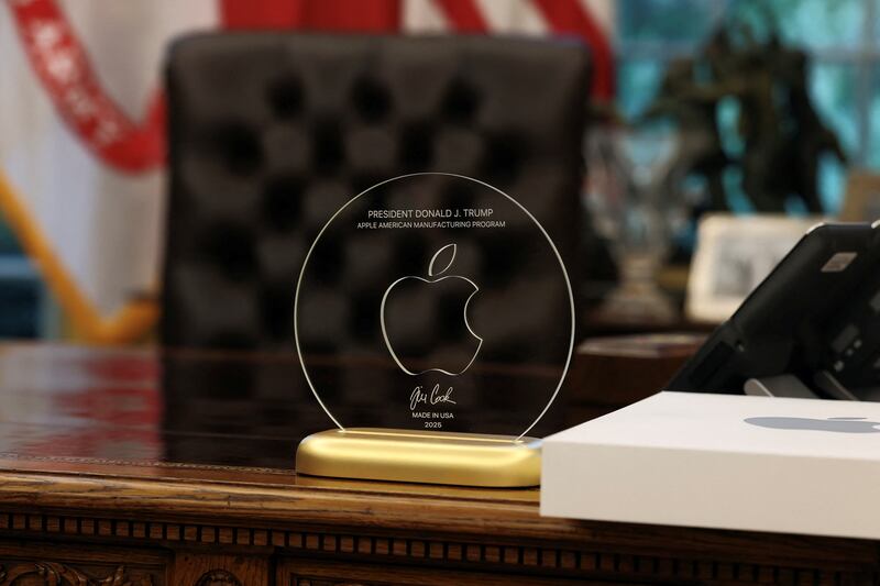 A gift given by Apple CEO Tim Cook to U.S. President Donald Trump stands on President Trump's table, as they present Apple's announcement of a $100 billion investment in U.S. manufacturing, in the Oval Office at the White House in Washington, D.C., U.S., August 6, 2025. REUTERS/Jonathan Ernst