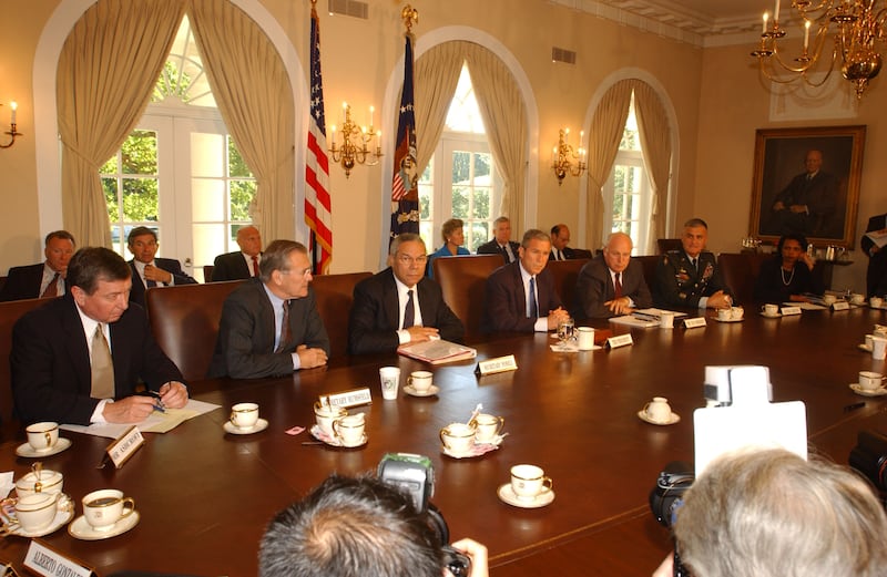 US President George W Bush (seated across table, fourth left) meets with his National Security Advisors in the White House's Cabinet Room, Washington DC, September 12, 2001. They were discussing the previous days terrorist attacks, involving hijacked commercial jetliners being deliberately crashed in buildings in Washington and New York (along with one further plane crashed in Shanksville, Pennsylvania). Pictured are, from left, Attorney General John Ashcroft, Secretary of Defense Donald Rumsfeld (1932 - 2021), Secretary of State Coin Powell, President Bush, Vice President Dick Cheney, Chairman of the Joint Chiefs of Staff Henry Shelton, and National Security Advisor Condoleezza Rice. (Photo by Ron Sachs/CNP/Getty Images)