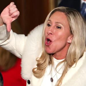 Marjorie Taylor Greene booing and giving a thumbs down gesture at Biden's State of the Union.