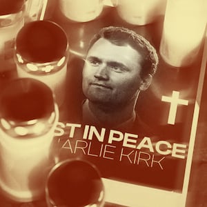 Photo illustration of a memorial of Charlie Kirk with candles obscuring a poster with "in peace" below his picture