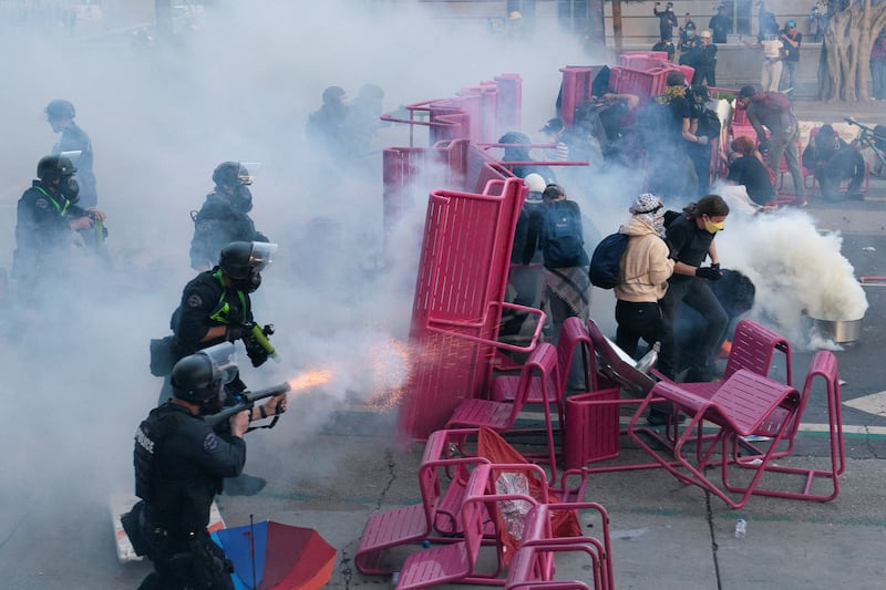 Police clear demonstrators after they blocked a street with a barricade during a protest against federal immigration sweeps in downtown Los Angeles,