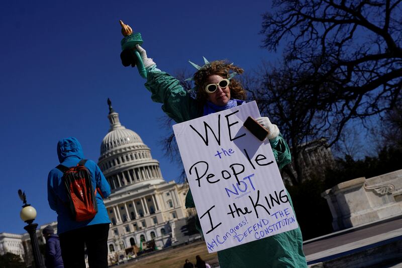 A demonstrator dressed as the Statue of Liberty takes part in a protest on Presidents' Day against President Donald Trump's actions in Washington, D.C. February 17, 2025.