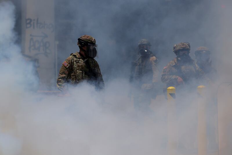 Smoke rises as members of the California National Guard gather during a protest against federal immigration sweeps in downtown Los Angeles.