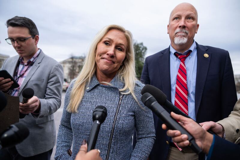 Reps. Marjorie Taylor Greene and Chip Roy talk with reporters about a bipartisan government funding bill outside the U.S. Capitol Building.