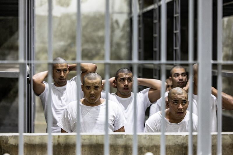 Alleged members of the Venezuelan gang Tren de Aragua and the MS-13 gang look on from inside a cell in CECOT.