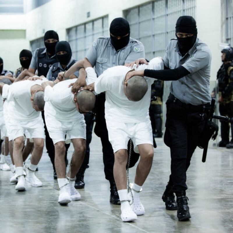 American deportees are frog-walked into a massive prison complex in El Salvador.