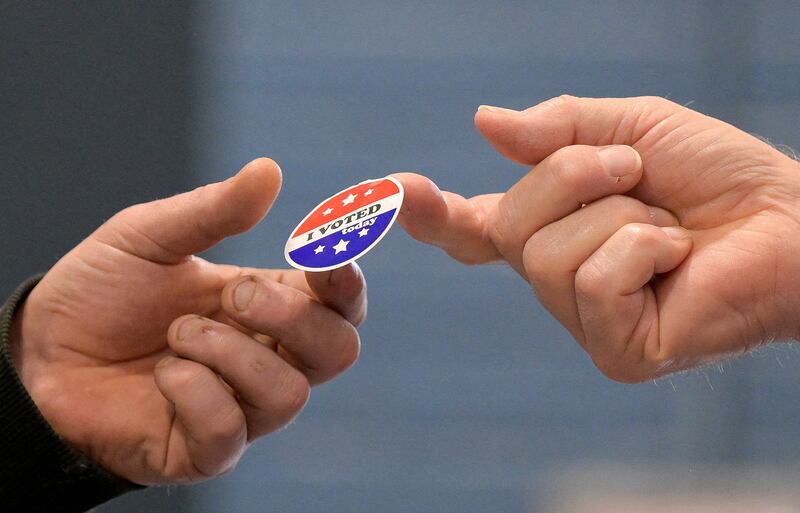 A voter receives a sticker after casting his ballot on Election Day, November 5, 2024,  in Gray, Maine.