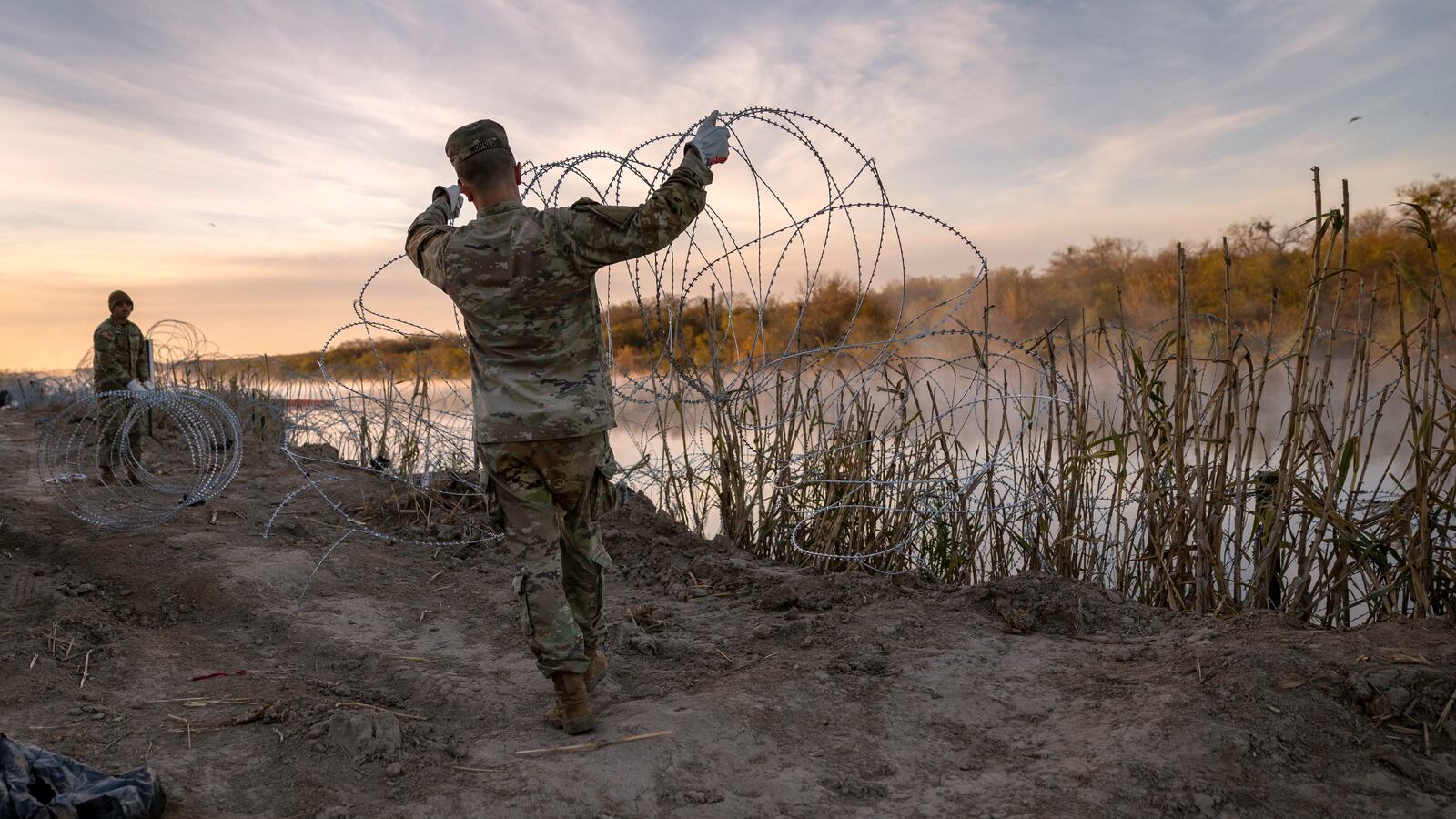 Texas National Guard soldiers install additional razor wire lie along the Rio Grande on January 10, 2024 in Eagle Pass, Texas.