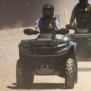 Homeland Security Secretary Kristi Noem rides an ATV along the U.S.-Mexico border.