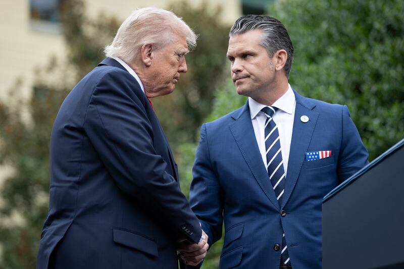 Donald Trump greets Pete Hegseth (R) during a September 11th observance event in the courtyard of the Pentagon September 11, 2025 in Arlington, Virginia.