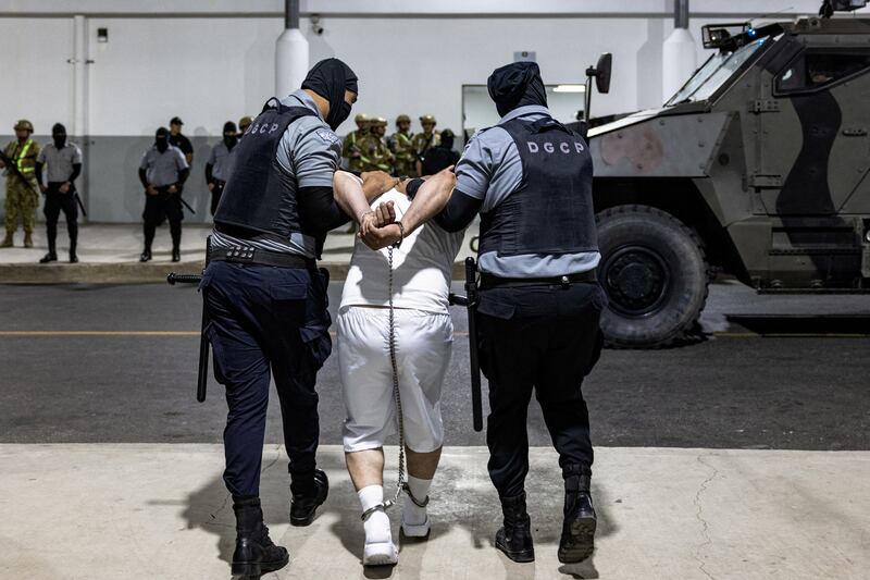 Salvadoran prison guards force a man into CECOT.