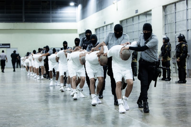 American deportees are frog-walked into a massive prison complex in El Salvador.