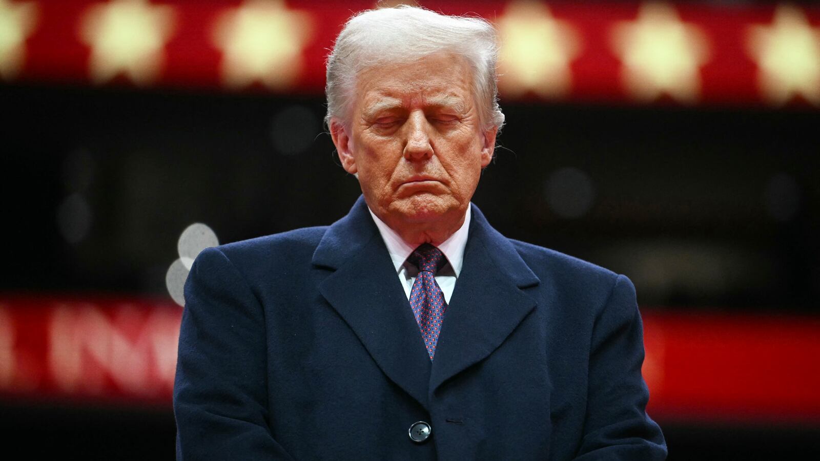 President Donald Trump closes his eyes as he observes a moment of silence for firefighter Corey Comperatore who was killed during the assassination attempt on Donald Trump, during the inaugural parade inside Capital One Arena, in Washington, DC,