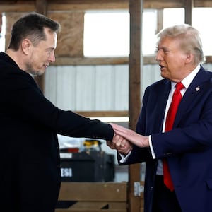Elon Musk shakes hands with Donald Trump