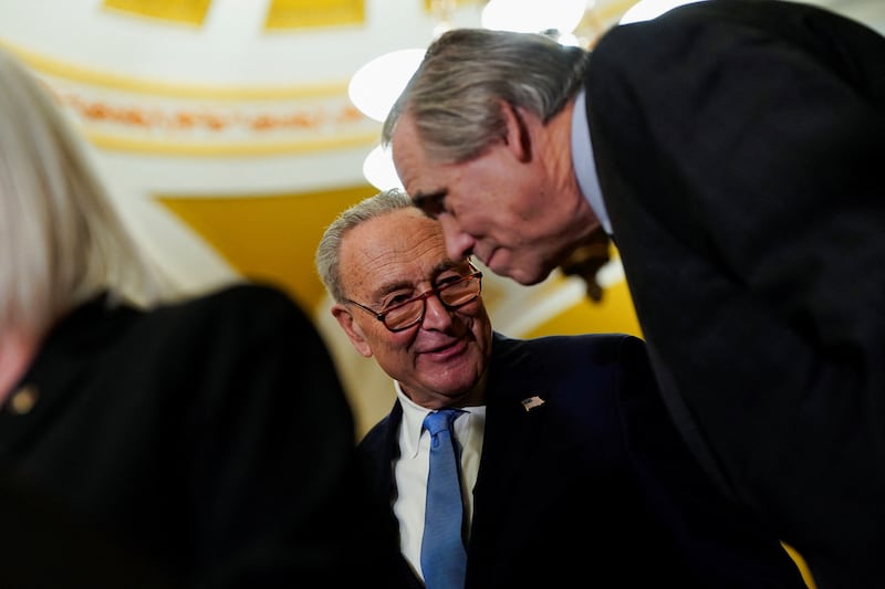 Chuck Schumer (left) speaks with U.S. Sen. Jeff Merkley (right) in February. The allies have become rivals this week regarding a stopgap funding bill proposed by Republicans.