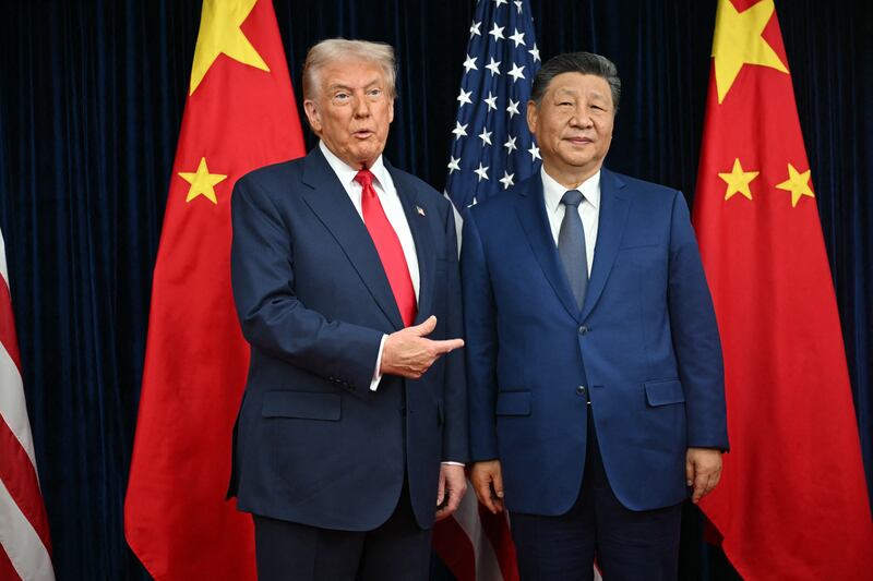 TOPSHOT - US President Donald Trump (L) and China's President Xi Jinping greet each other as they arrive for talks at the Gimhae Air Base, located next to the Gimhae International Airport in Busan on October 30, 2025. Donald Trump and Chinese leader Xi Jinping will seek a truce in their bruising trade war on October 30, with the US president predicting a "great meeting" but Beijing being more circumspect. (Photo by ANDREW CABALLERO-REYNOLDS / AFP) (Photo by ANDREW CABALLERO-REYNOLDS/AFP via Getty Images)