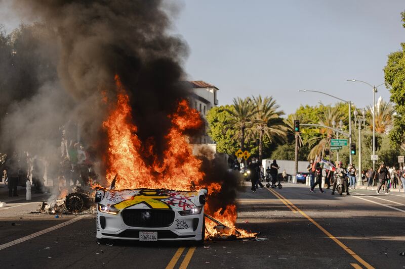 Several cars burn on North Los Angeles street during clashes between protesters and police on June 8, 2025 in Downtown Los Angeles, California.