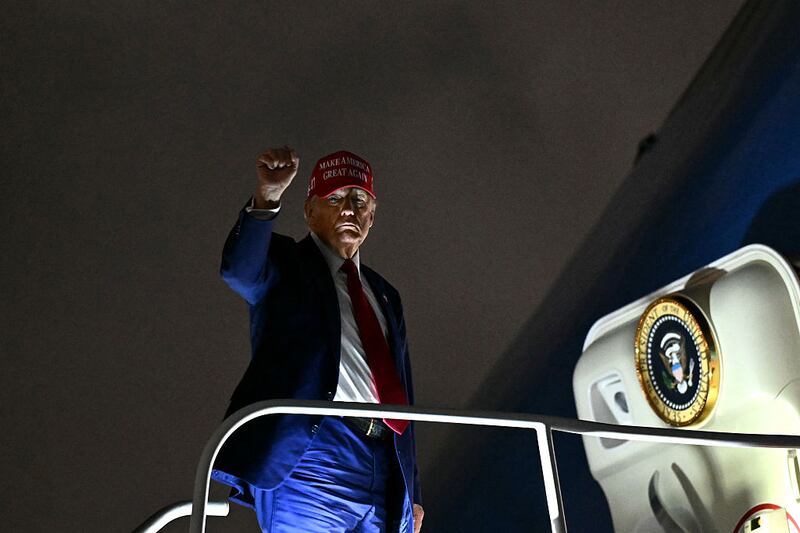 US President Donald Trump pumps his fist as he boards Air Force One.